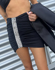 Gonna mini nera drappeggiata con ricamo gioiello