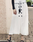 Gonna lunga bianca con ricami neri e nappe