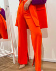 Pantaloni flare arancio con spacchetti sul fondo